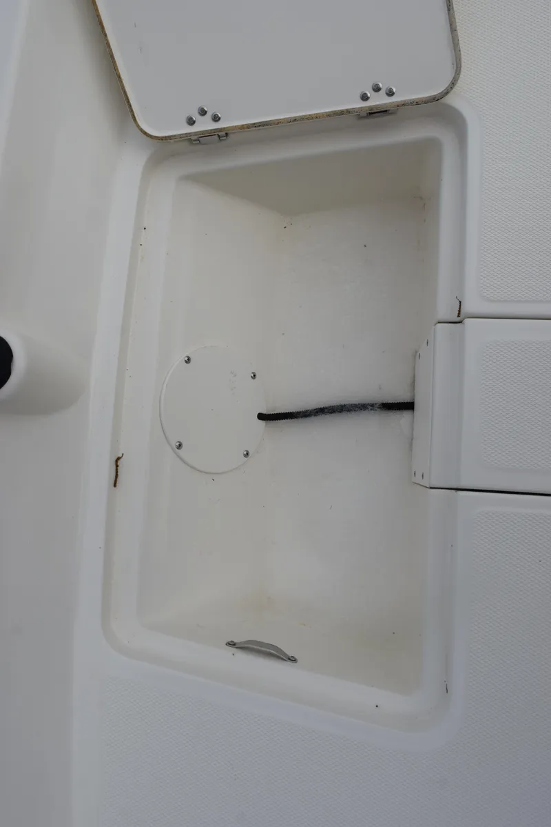 Slide: The Image of 2022 Mako Pro Skiff 17 CC storage compartment, open and empty. - 22