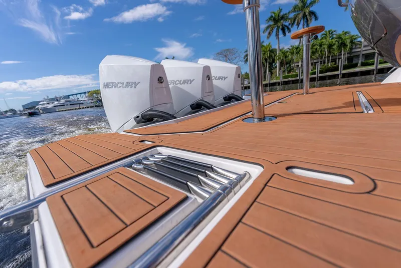 Slide: The Image of 2024 Hanover 415 boat deck with Mercury engines, featuring sleek wood finish and stainless steel accents. - 23