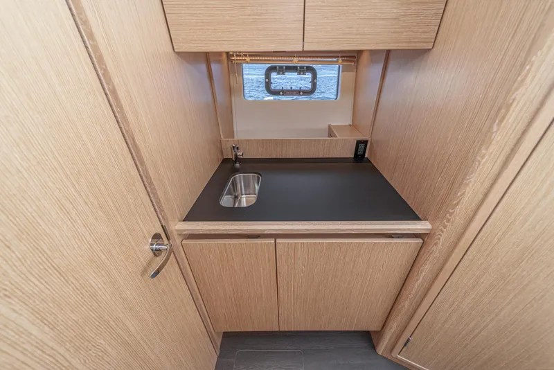 Slide: The Image of Modern kitchenette in 2023 Bavaria SR36 yacht with wood cabinetry and compact sink. - 46