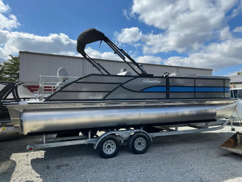 Slide: The Image of 2025 Bentley Pontoons Legacy 243 QSB Dual Captain Full Tube on trailer, under cloudy sky. - 21