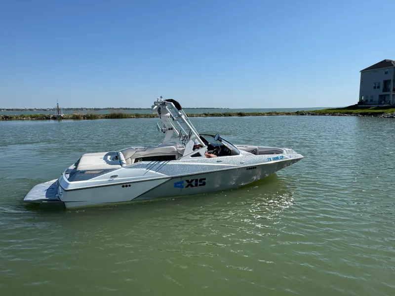 Slide: The Image of 2015 Axis A22 boat on calm water under clear blue sky. - 3