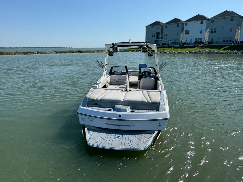 Slide: The Image of 2015 Axis A22 boat on calm water near residential buildings. - 5