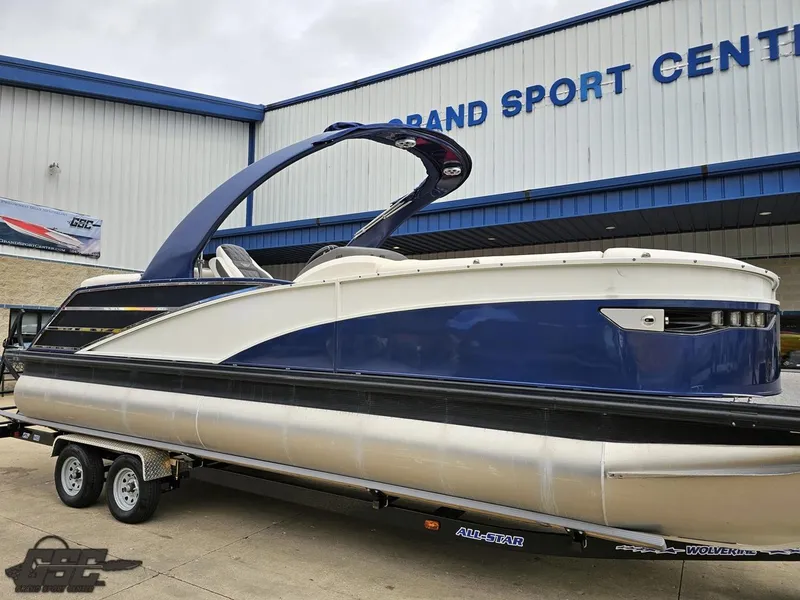 Slide: The Image of 2021 Bennington RX 25 Quad Bench pontoon boat on trailer at dealership. - 11