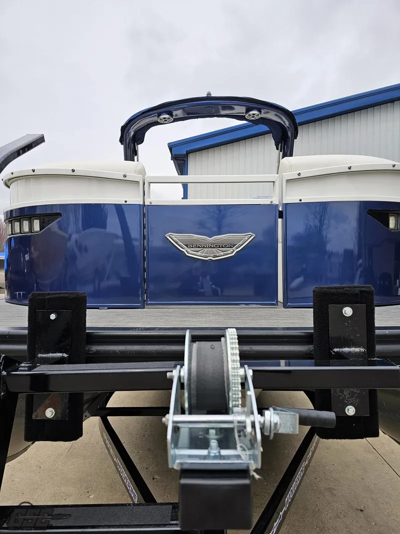 Slide: The Image of 2021 Bennington RX 25 Quad Bench pontoon boat on trailer, blue exterior, rear view. - 13