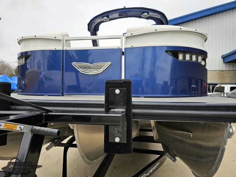 Slide: The Image of 2021 Bennington RX 25 Quad Bench pontoon boat on trailer, blue exterior, rear view. - 16