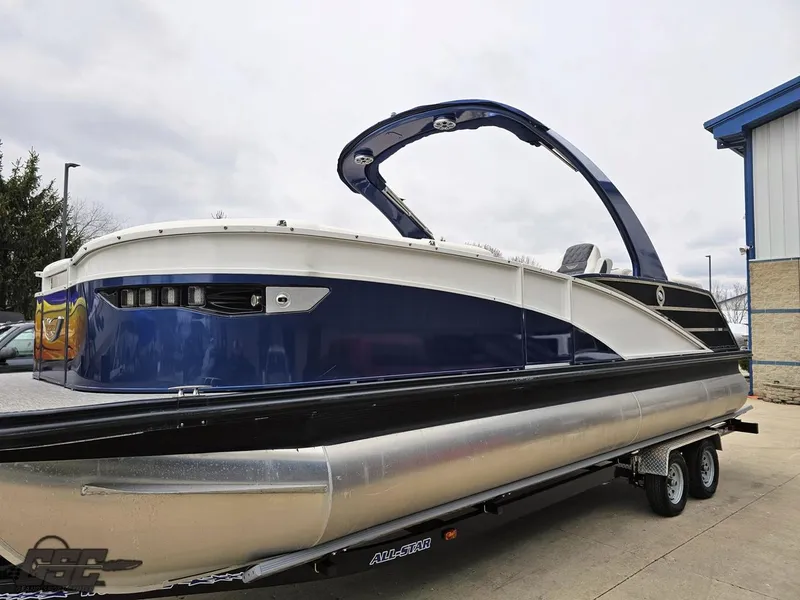 Slide: The Image of 2021 Bennington RX 25 Quad Bench pontoon boat on a trailer, side view. - 18