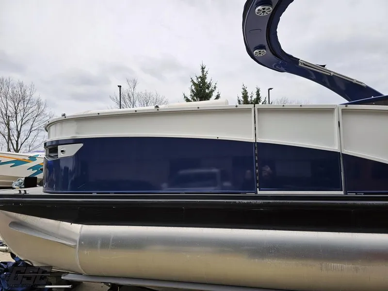 Slide: The Image of 2021 Bennington RX 25 Quad Bench pontoon boat with sleek blue and white design. - 20