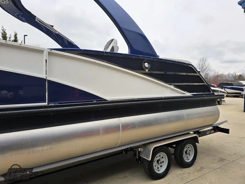 Slide: The Image of 2021 Bennington RX 25 Quad Bench pontoon boat on a trailer, side view. - 21