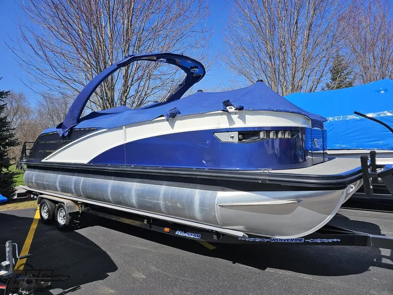 Slide: The Image of 2021 Bennington RX 25 Quad Bench pontoon boat on trailer, covered and parked outdoors. - 3