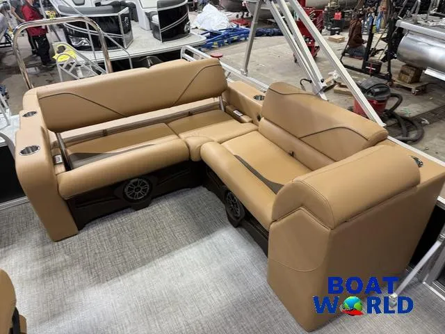 Slide: The Image of 2025 Tahoe Sport 2385 Swingback Tritoon interior with tan seating, showcased at Boat World. - 15