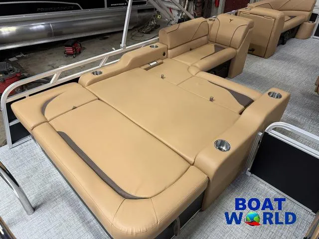 Slide: The Image of 2025 Tahoe Sport 2385 Swingback Tritoon interior with tan seating and cup holders. - 16