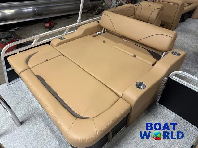 Slide: The Image of 2025 Tahoe Sport 2385 Swingback Tritoon with tan seating and cup holders, showcased at Boat World. - 18