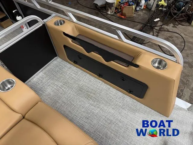 Slide: The Image of 2025 Tahoe Sport 2385 Swingback Tritoon interior with tan seating and cup holders. - 21