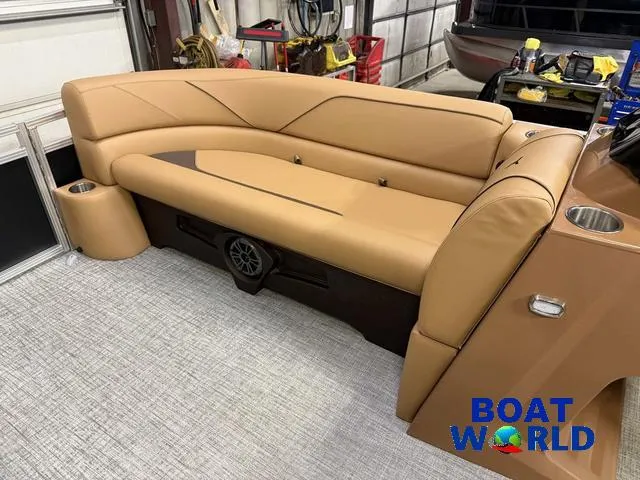 Slide: The Image of 2025 Tahoe Sport 2385 Swingback Tritoon interior with tan seating and cup holders. - 27