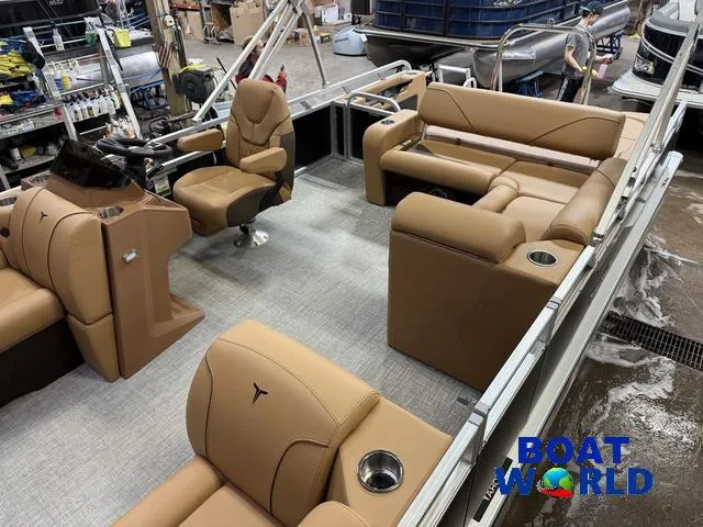Slide: The Image of 2025 Tahoe Sport 2385 Swingback Tritoon interior with tan seating and steering console. - 4