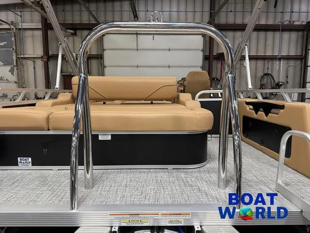 Slide: The Image of 2025 Tahoe Sport 2385 Swingback Tritoon with tan seating and chrome railings in a showroom. - 40