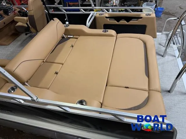 Slide: The Image of 2025 Tahoe Sport 2385 Swingback Tritoon interior with tan seating, showcased at Boat World. - 5