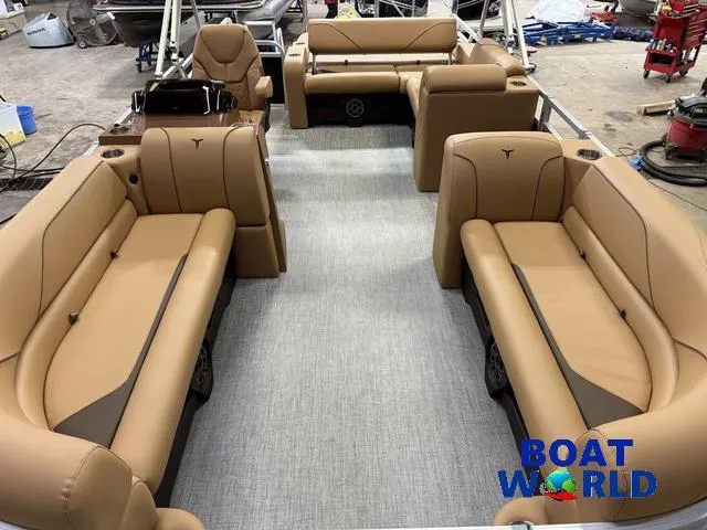 Slide: The Image of 2025 Tahoe Sport 2385 Swingback Tritoon interior with tan seating, showcased at Boat World. - 7