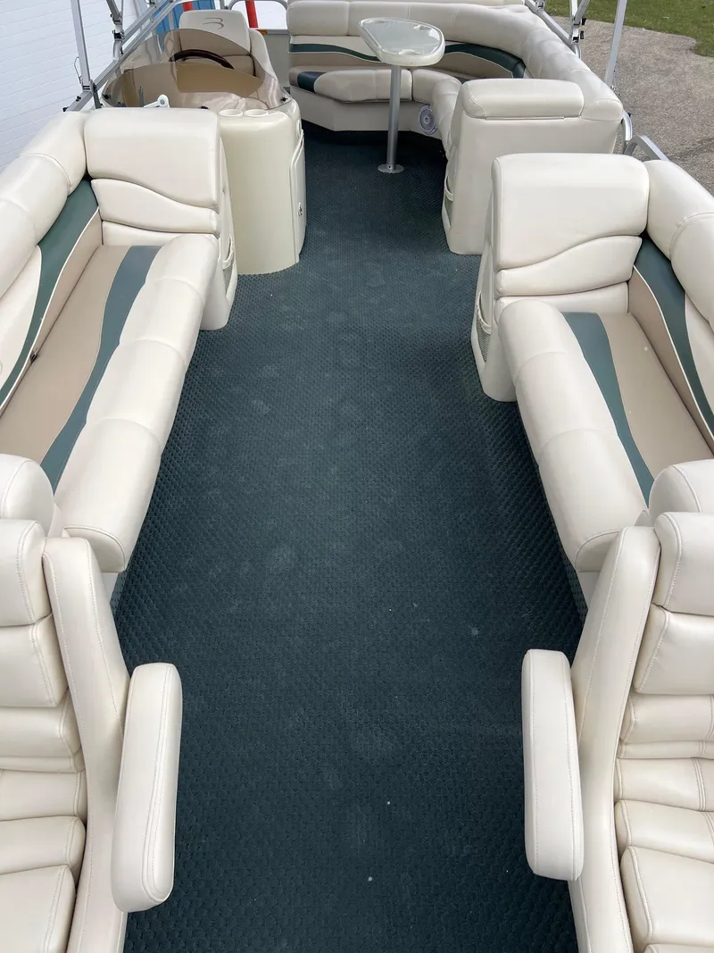 Slide: The Image of 2002 Bennington 2575 FS pontoon boat interior with beige seating and blue carpet. - 14