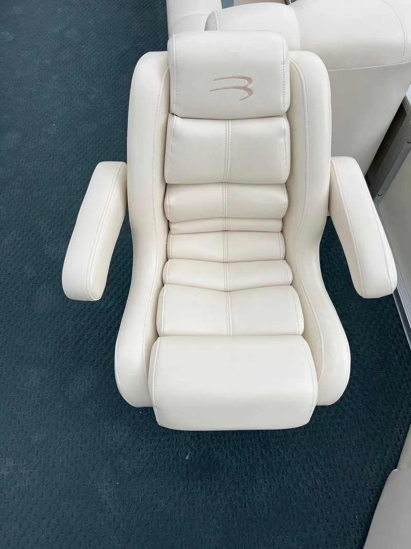 Slide: The Image of Luxurious white captain's chair on a 2002 Bennington 2575 FS boat. - 16