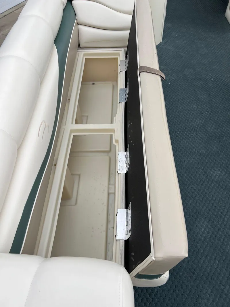 Slide: The Image of 2002 Bennington 2575 FS boat seat storage compartment with open lid, showcasing spacious interior. - 19