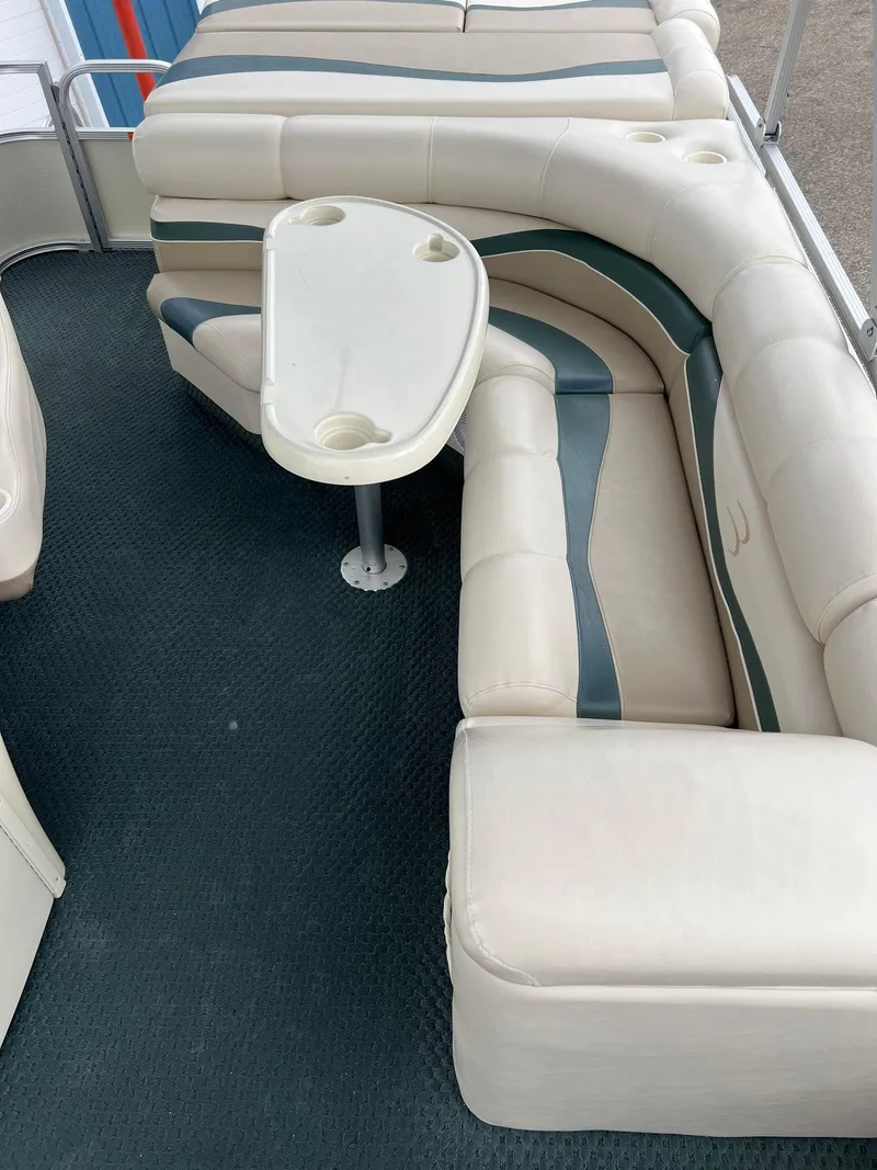 Slide: The Image of 2002 Bennington 2575 FS boat interior with beige seating and table. - 24