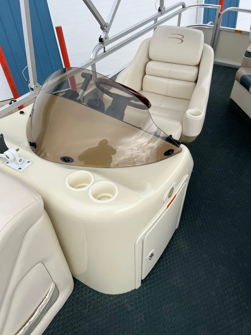 Slide: The Image of 2002 Bennington 2575 FS boat interior with beige seating and console. - 25