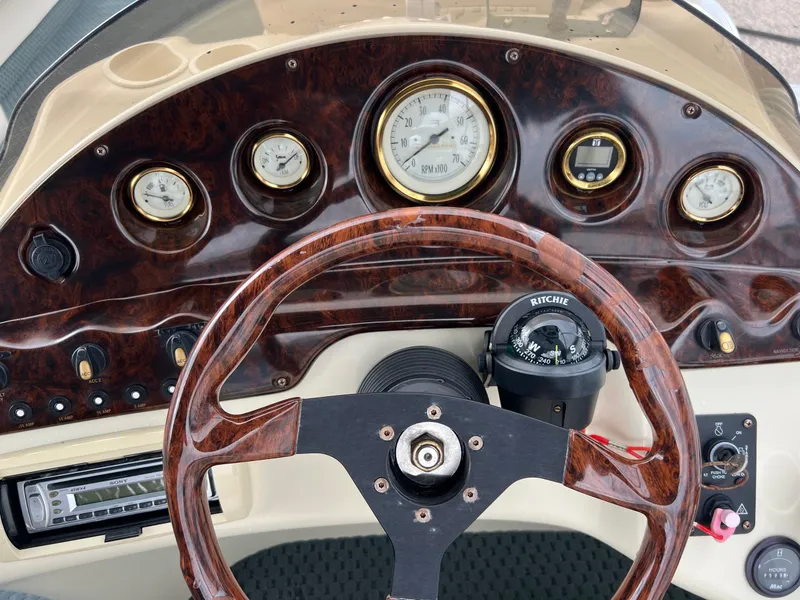Slide: The Image of Dashboard of a 2002 Bennington 2575 FS boat with wood finish and gauges. - 27