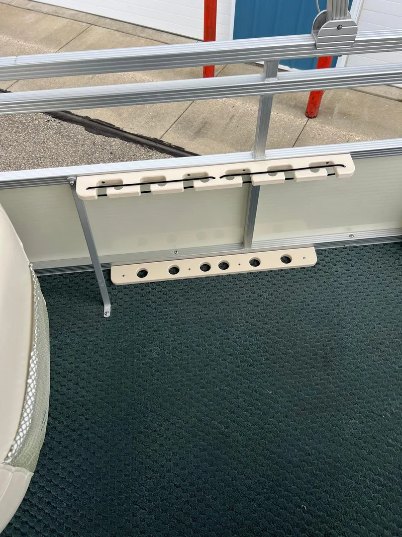 Slide: The Image of Bennington 2575 FS 2002 boat interior with rod holders and carpeted floor. - 30