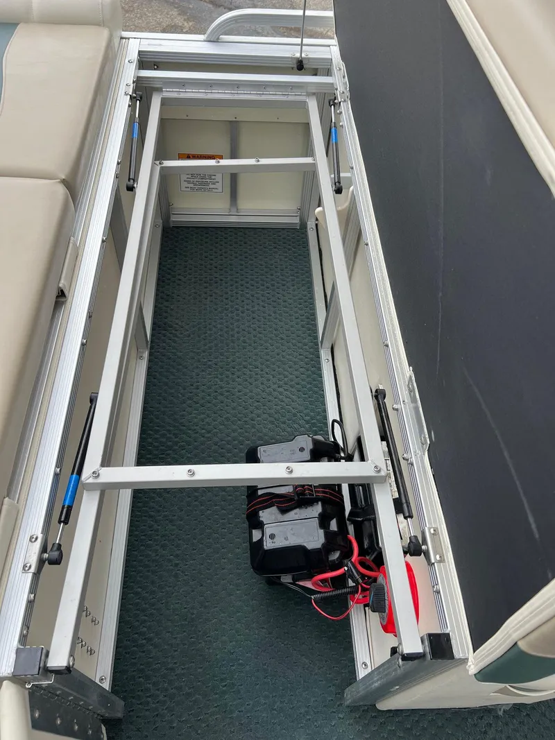 Slide: The Image of Open storage compartment in a 2002 Bennington 2575 FS boat, showing battery and wiring. - 32