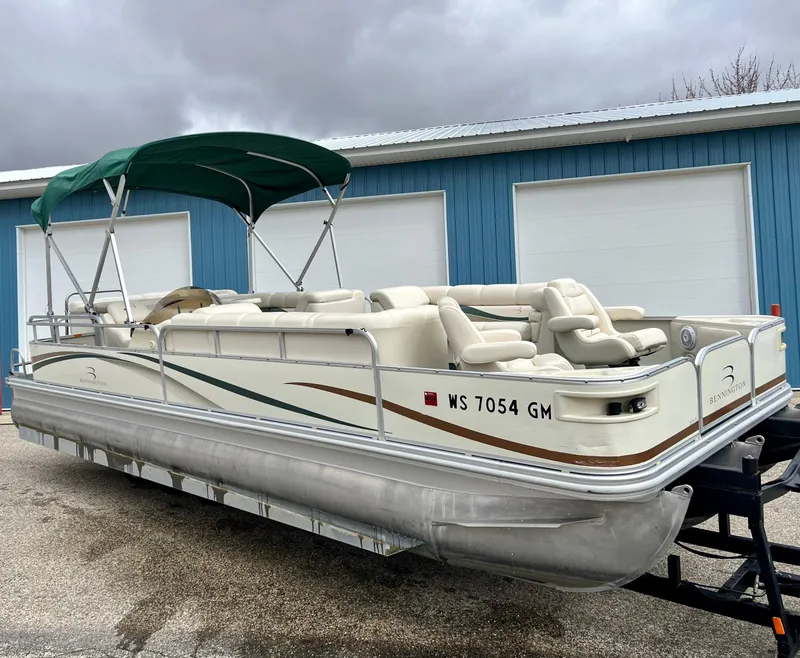 Slide: The Image of 2002 Bennington 2575 FS pontoon boat with canopy, parked on trailer near blue building. - 4