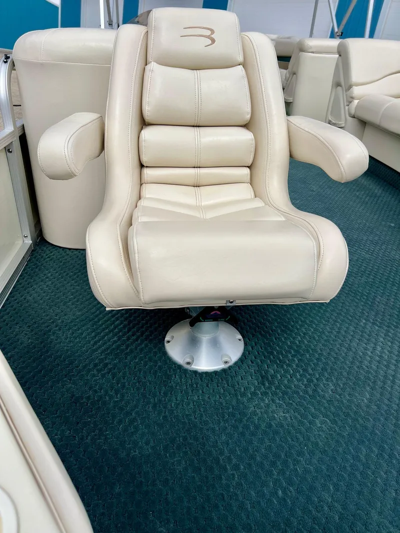 Slide: The Image of Luxurious beige captain's chair on 2002 Bennington 2575 FS boat, set against blue carpet. - 7