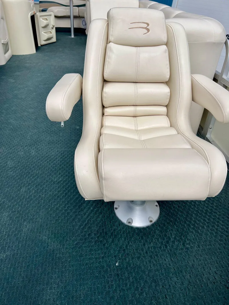 Slide: The Image of Luxurious beige captain's chair on 2002 Bennington 2575 FS boat, set against blue carpet. - 8