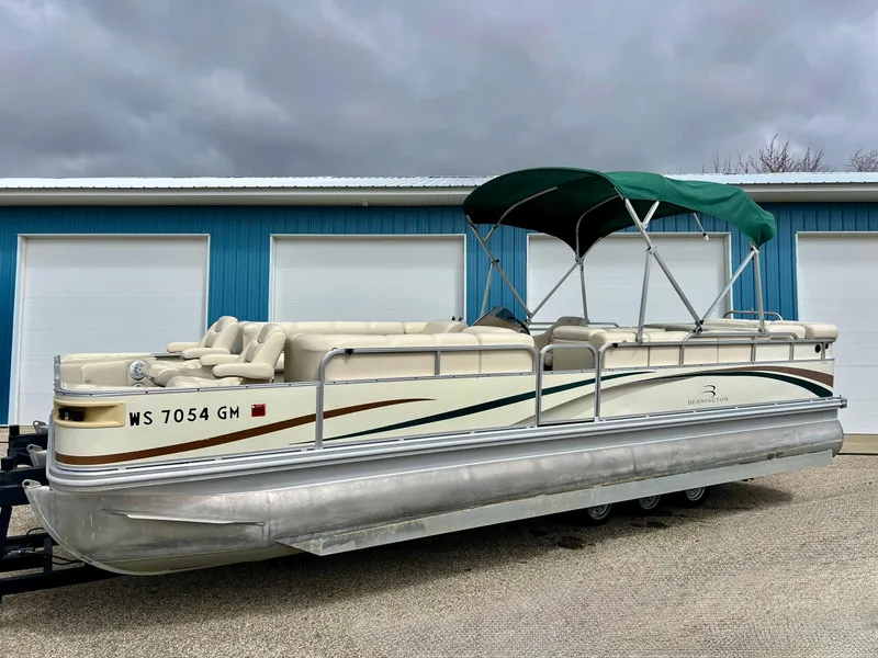 Slide: The Image of 2002 Bennington 2575 FS pontoon boat with canopy, parked near blue garage doors. - 9