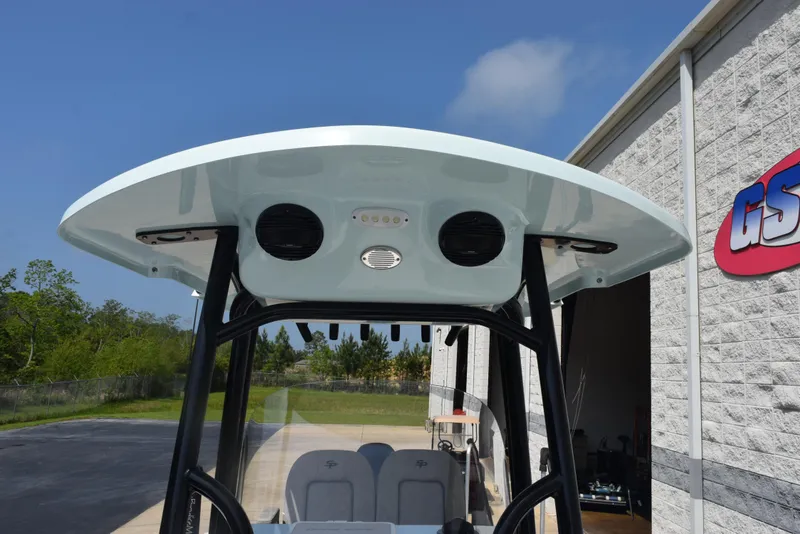 Slide: The Image of 2023 Sea Pro 219 Deep V CC boat with T-top and speakers, parked near a building. - 14