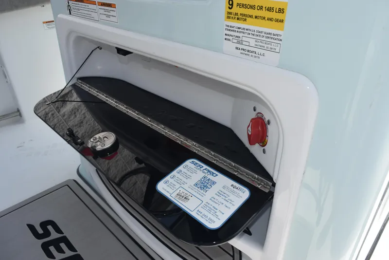 Slide: The Image of 2023 Sea Pro 219 Deep V CC boat storage compartment with capacity label and safety instructions. - 20