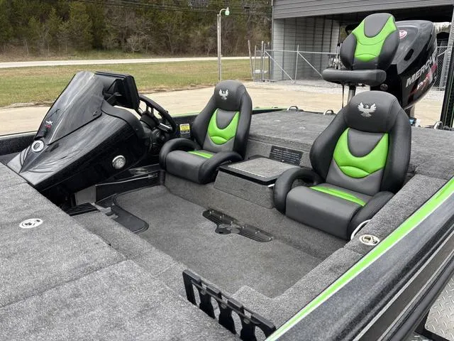 Slide: The Image of 2014 Phoenix Bass Boats 920 ProXP interior with green-accented seats and modern dashboard. - 10