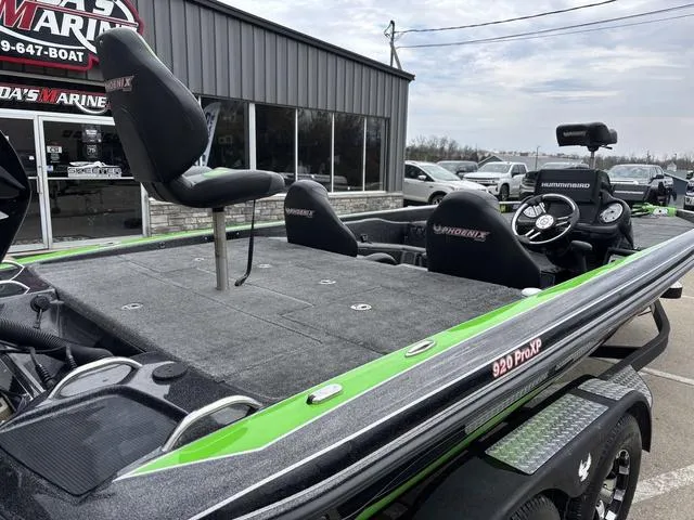 Slide: The Image of 2014 Phoenix Bass Boats 920 ProXP with green accents, parked outside a marine shop. - 3