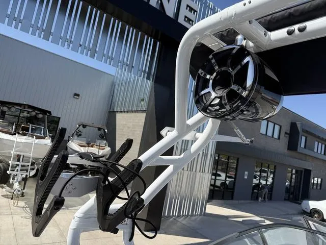 Slide: The Image of 2025 Moomba Max boat with wakeboard rack and speaker, displayed outdoors. - 13