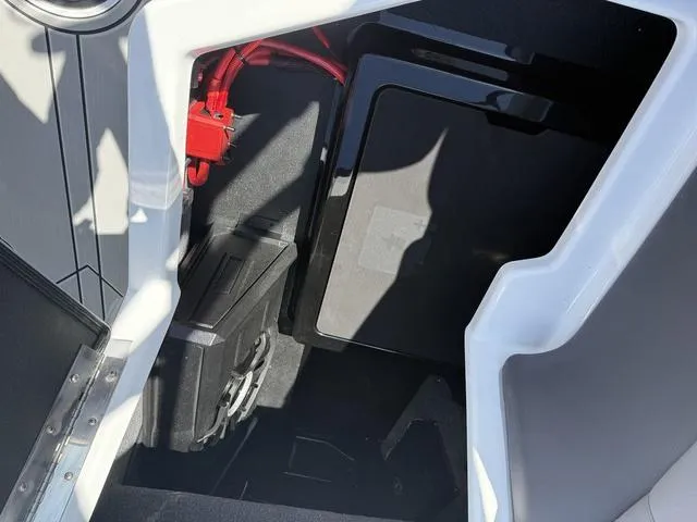 Slide: The Image of 2025 Moomba Max boat interior storage compartment with red wiring and black panel. - 15