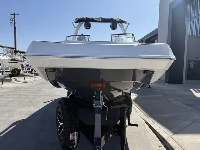 Slide: The Image of 2025 Moomba Max boat on trailer, front view, parked outdoors under clear sky. - 3