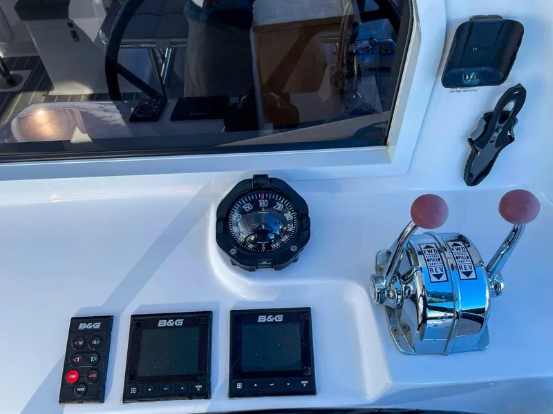 Slide: The Image of Helm controls of 2023 Seawind 1260 catamaran with compass and navigation instruments. - 11