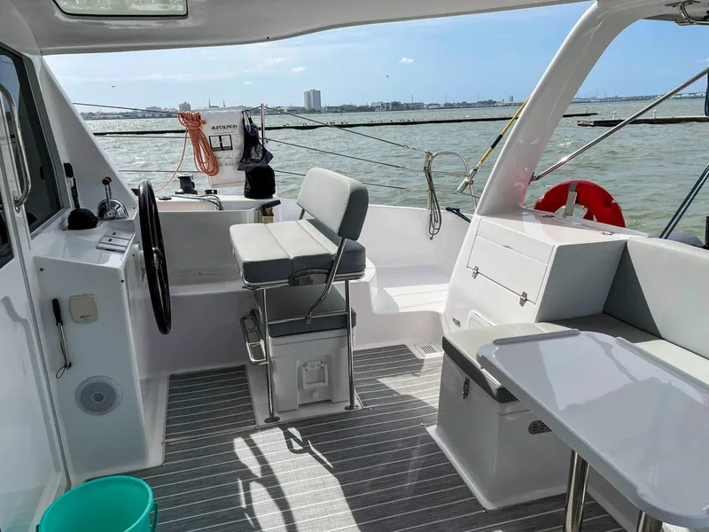 Slide: The Image of 2023 Seawind 1260 yacht cockpit with seating, steering wheel, and ocean view. - 18