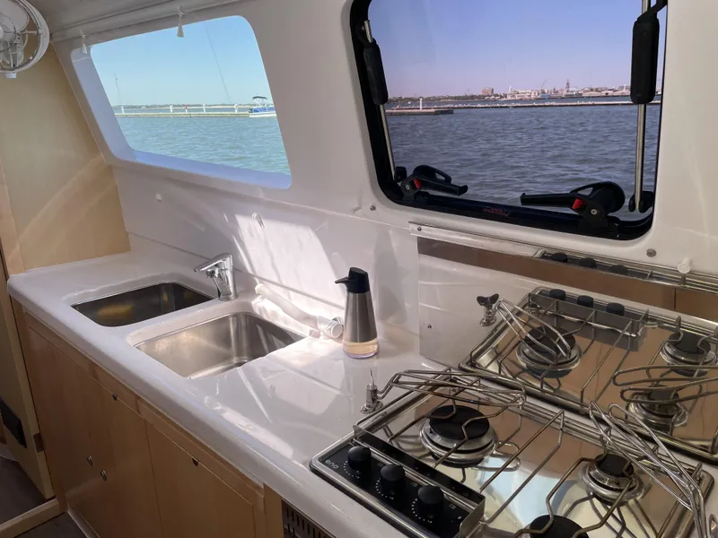 Slide: The Image of Modern kitchen in 2023 Seawind 1260 catamaran with stove, sink, and ocean view. - 24