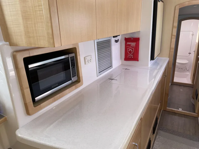 Slide: The Image of Modern kitchen interior of 2023 Seawind 1260 catamaran with microwave and fire blanket. - 25
