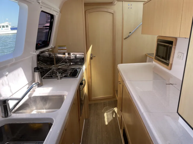 Slide: The Image of Modern galley kitchen in 2023 Seawind 1260 catamaran with stove, sink, and microwave. - 27