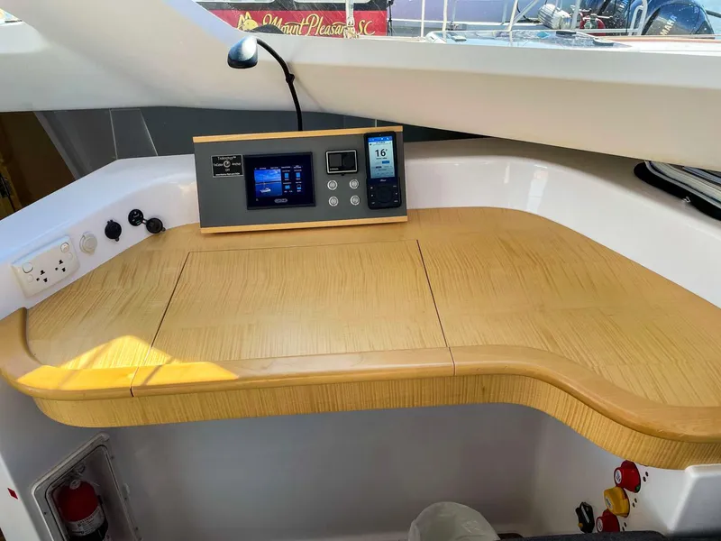 Slide: The Image of Navigation station on 2023 Seawind 1260 catamaran with control panel and wooden desk. - 33