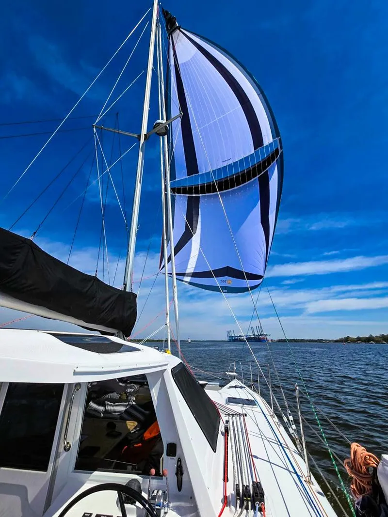 Slide: The Image of 2023 Seawind 1260 catamaran sailing on open water under a clear blue sky. - 4