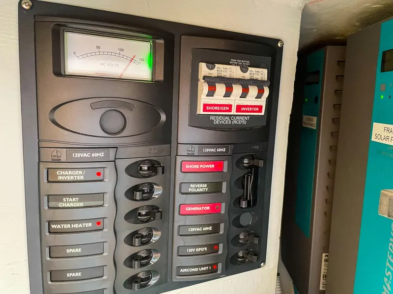 Slide: The Image of Electrical control panel on a 2023 Seawind 1260 catamaran, featuring various switches and meters. - 41
