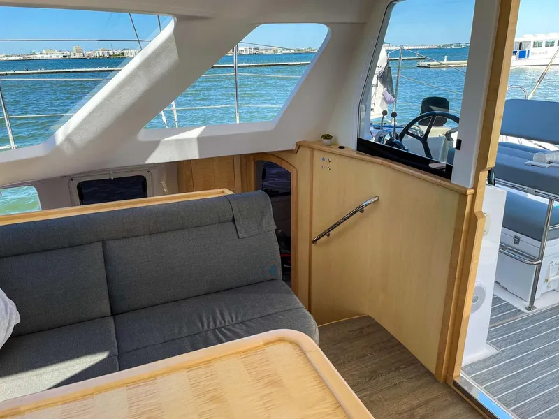 Slide: The Image of Interior of 2023 Seawind 1260 catamaran with sofa, table, and helm view. - 45